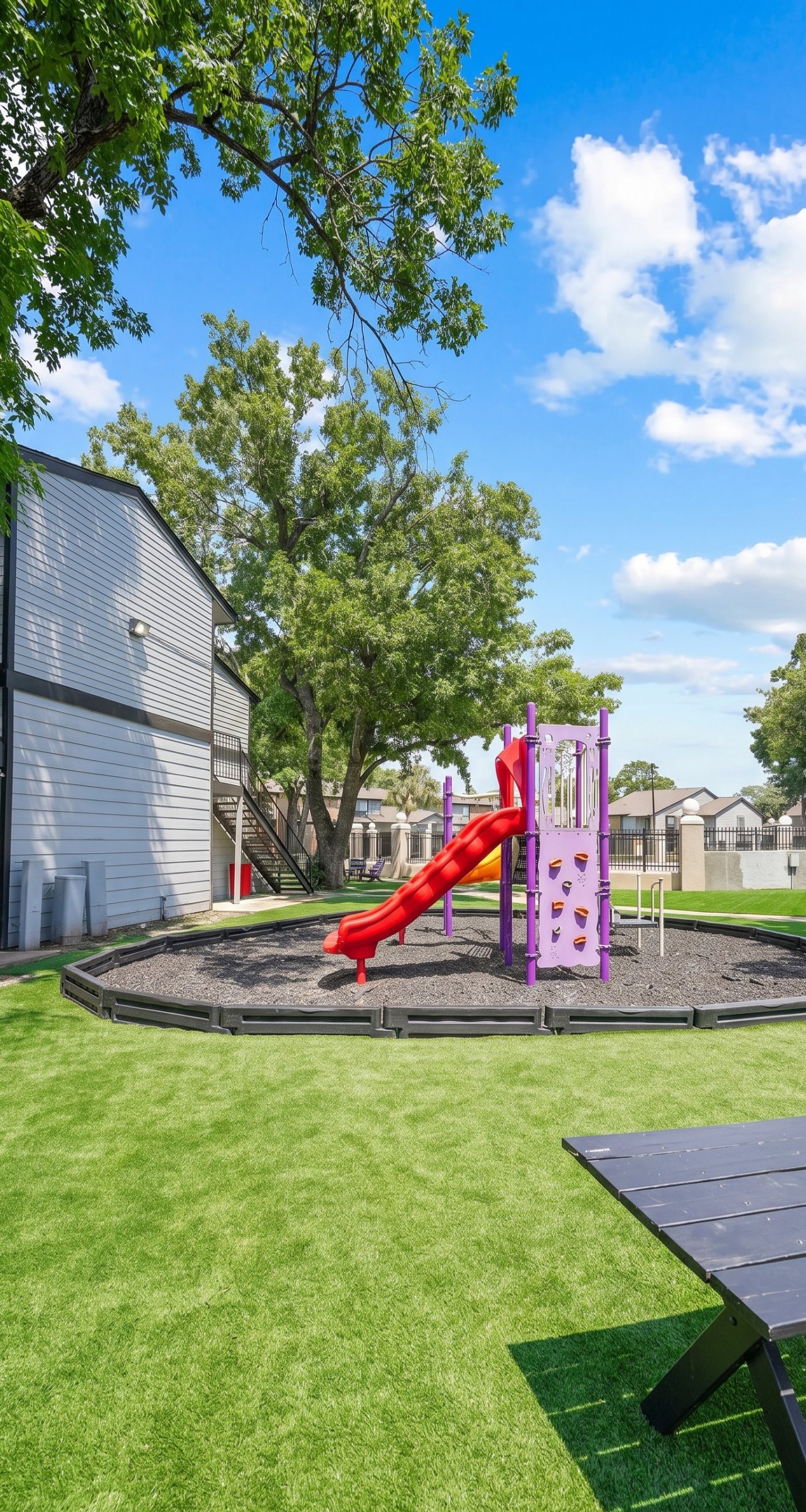 Colorful playground slide at Falls of Gessner apartments in Houston