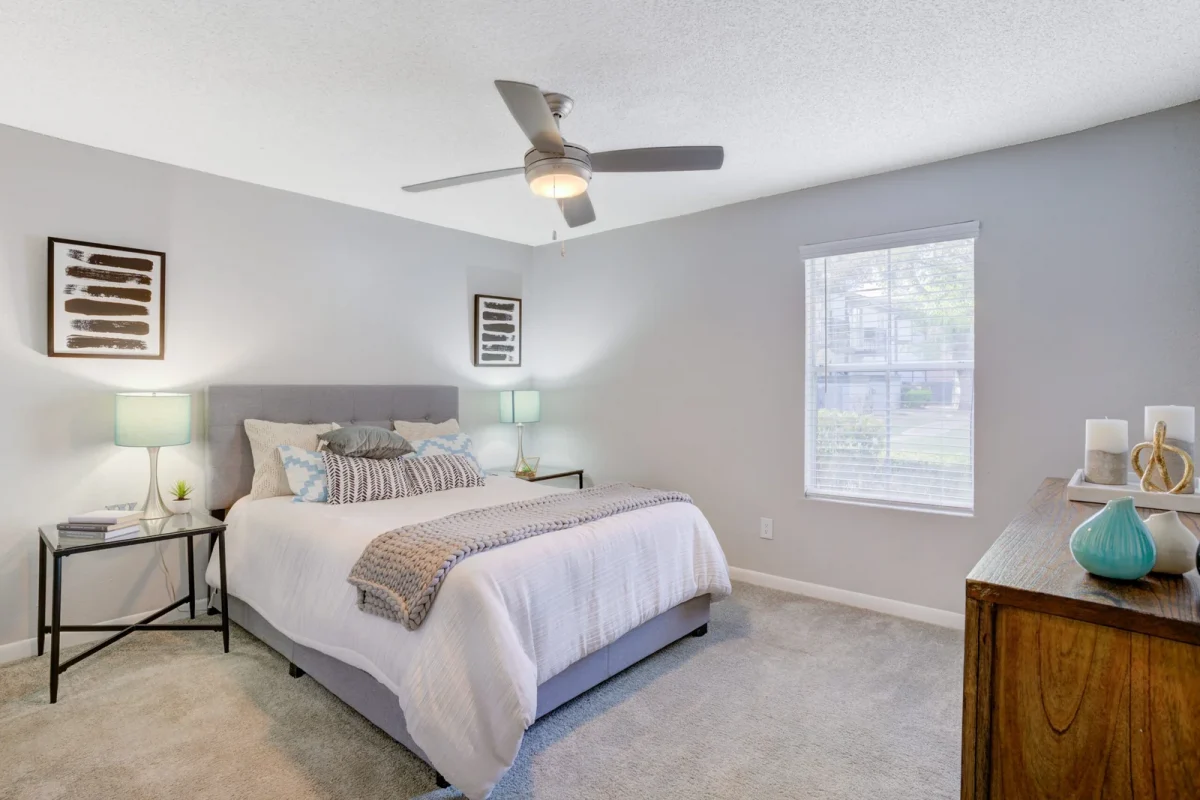 Bedroom with ceiling fan and large window at Falls of Gessner