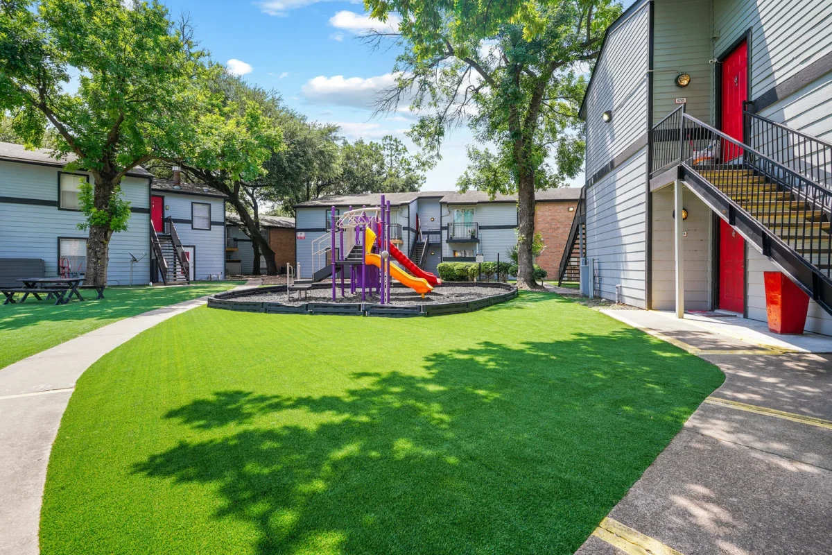 Playground and green lawn at Falls of Gessner